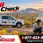 Driver checking tire pressure at a desert overlook in fall with a Dugger's Road Rescue truck nearby